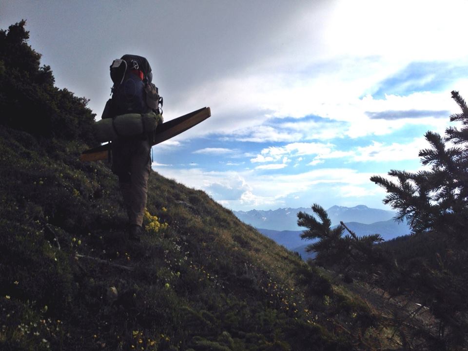 Man standing on a ridge of the mountain preparing to hike