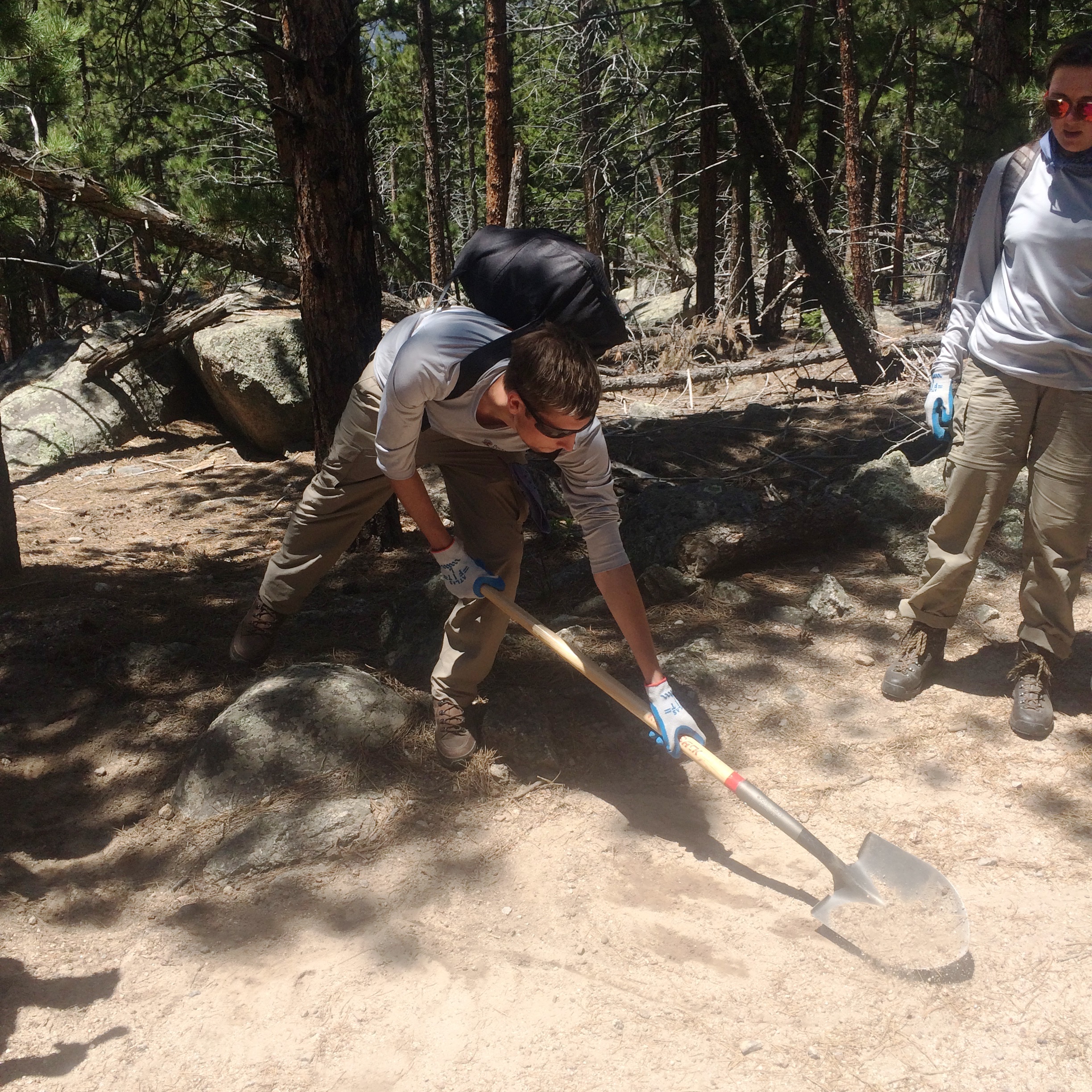RMC-CC crew member, Galen demonstrates how to dig and maintain drainages on trails. 