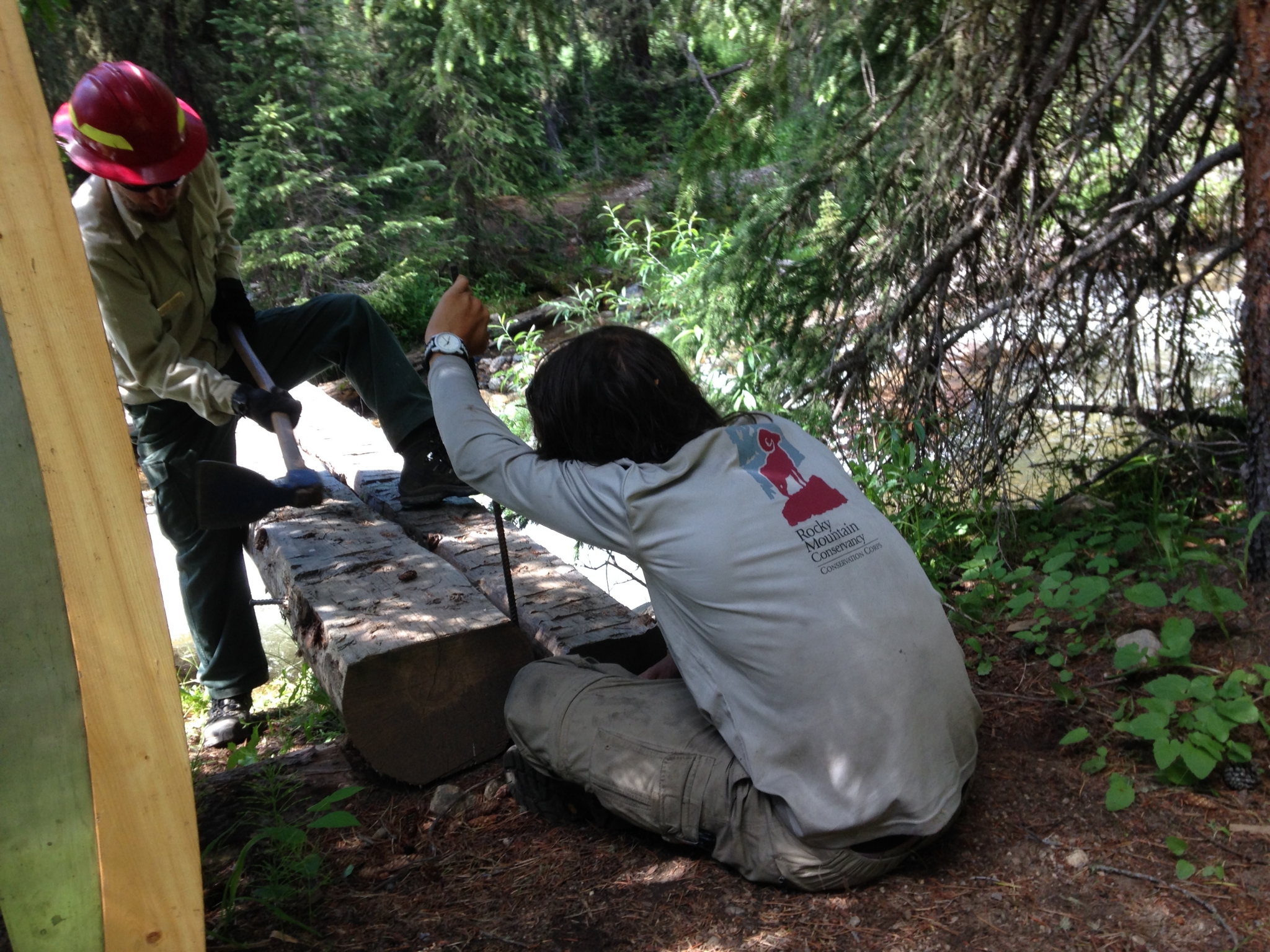 Elias helping repair a backcountry bridge with USFS supervisor Cory