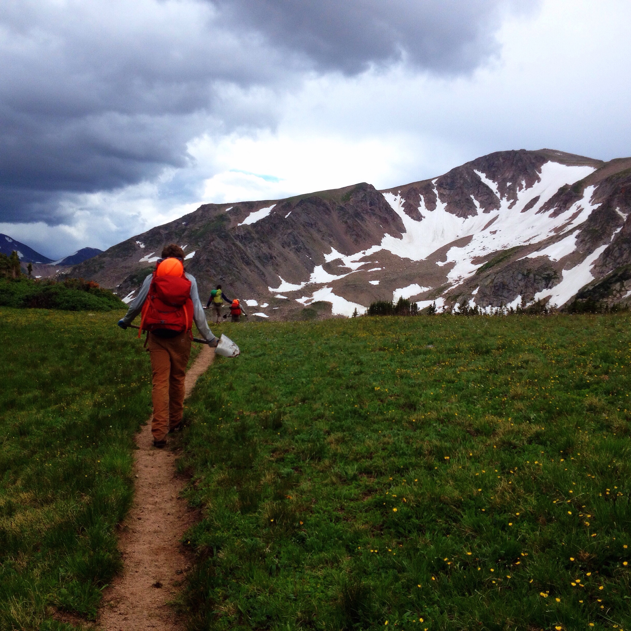 The crew hiking off of Grassy Pass as ominous clouds roll in