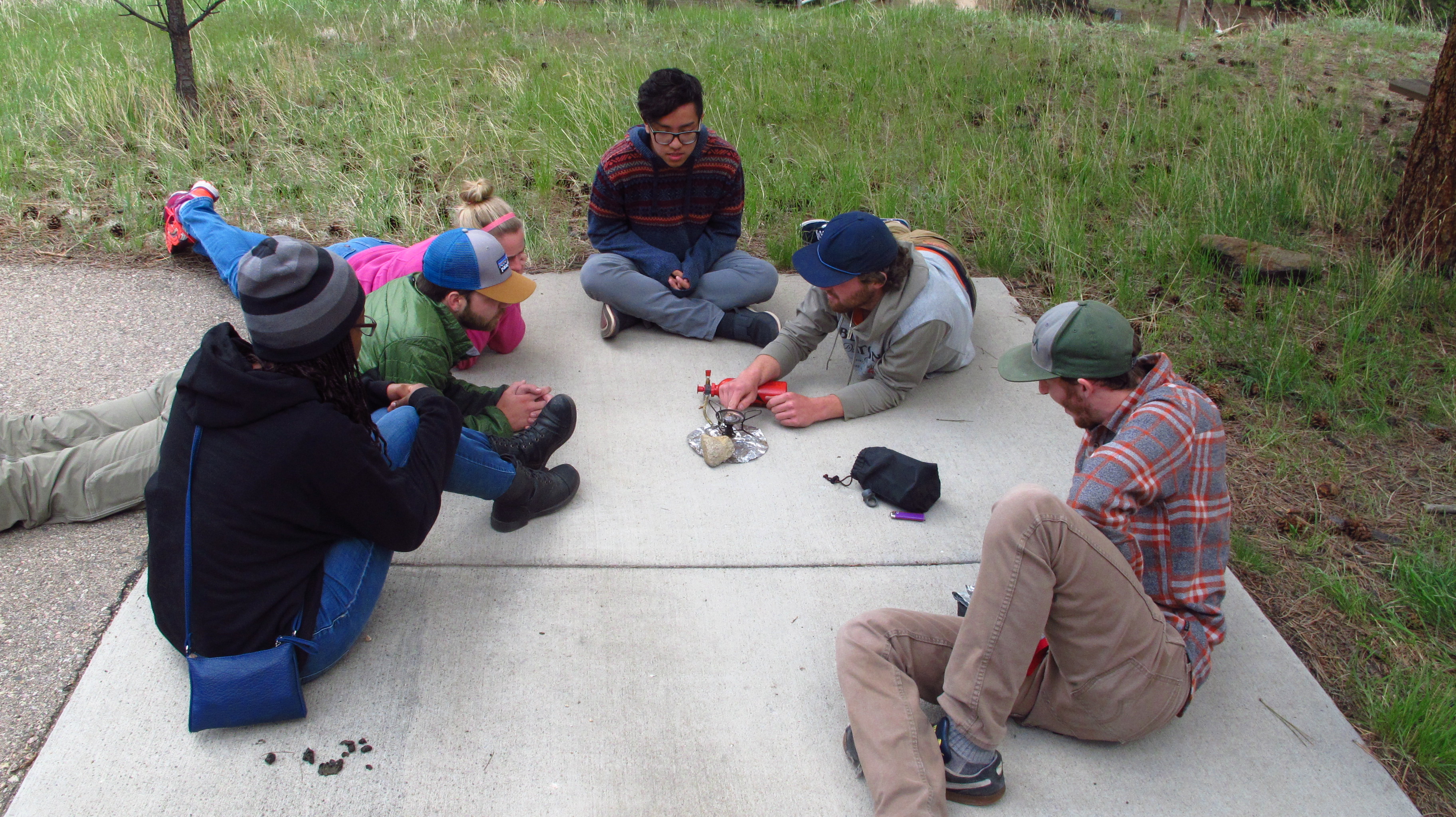 Group of friends sitting on the ground learning about whisperlite