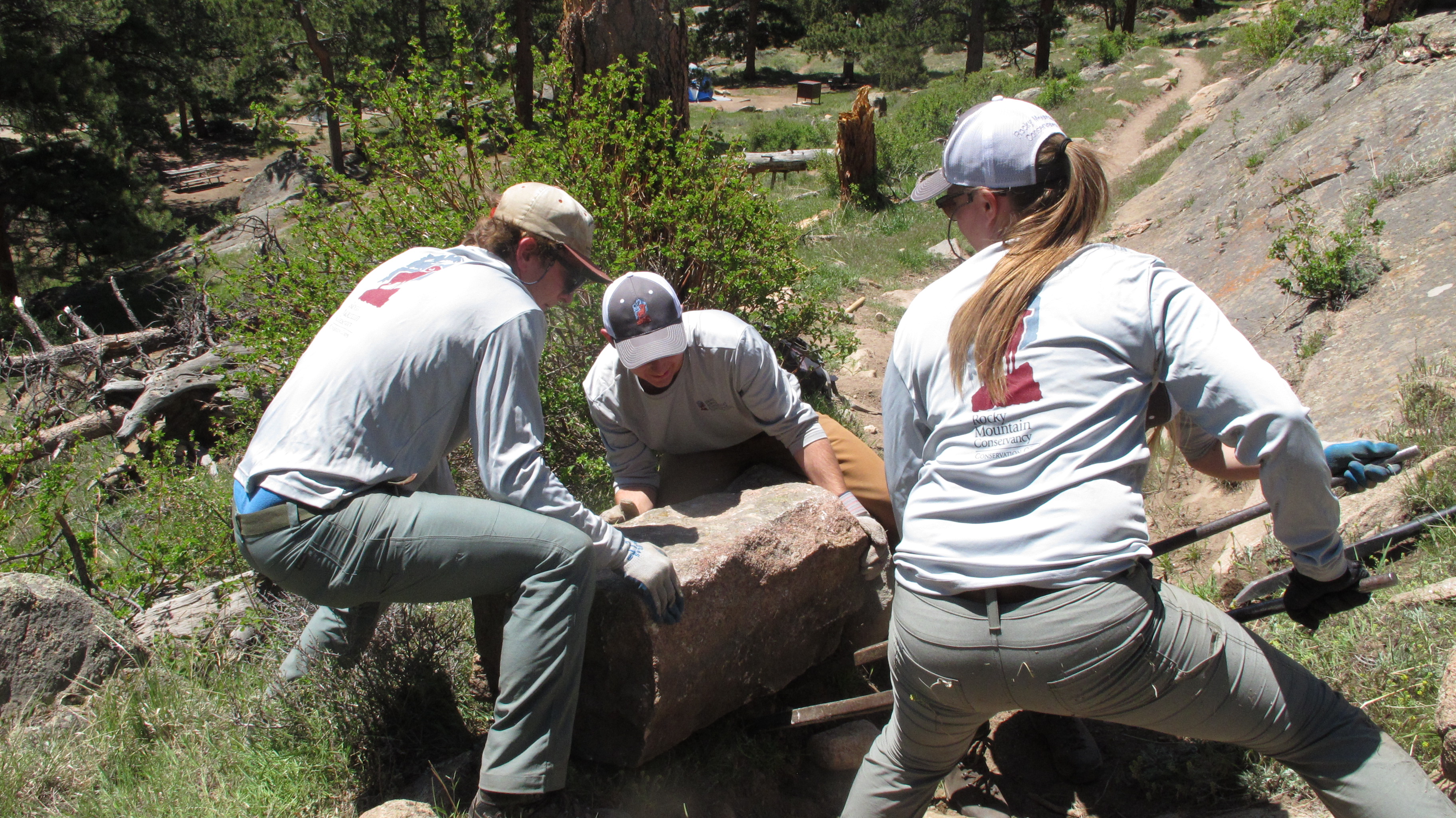 Group of workers lifting a rock