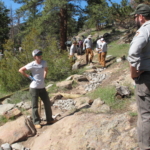 A group of people standing on a rocky trail.
