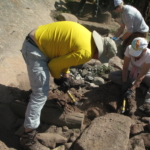 A group of people working on a rock.