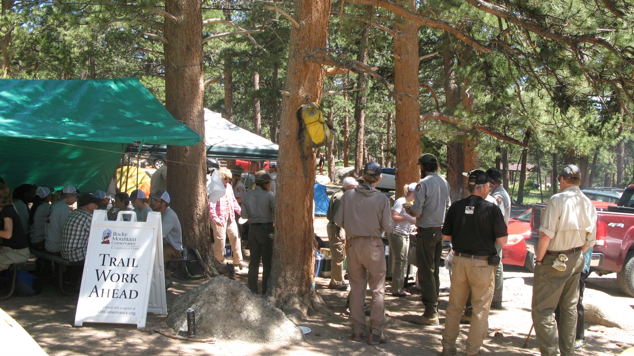 Workers standing beside trees to rest and have snacks