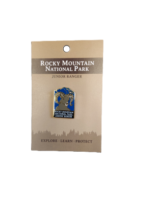 Rocky Mountain National Park Junior Ranger Pin displayed on a brown card with the text: "Explore - Learn - Protect.