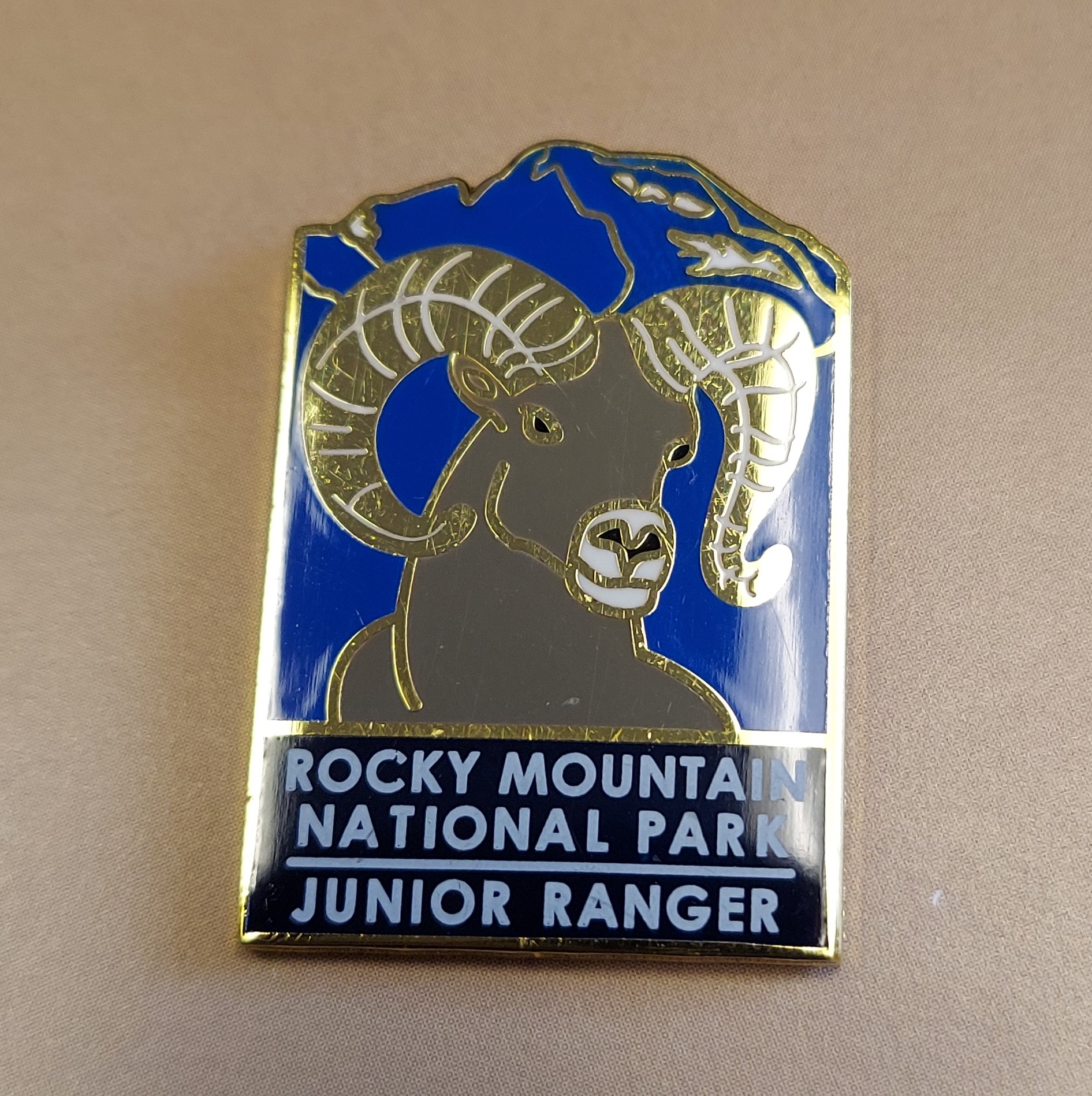 Junior Ranger pin showcasing a bighorn sheep with the text: "Rocky Mountain National Park Junior Ranger.