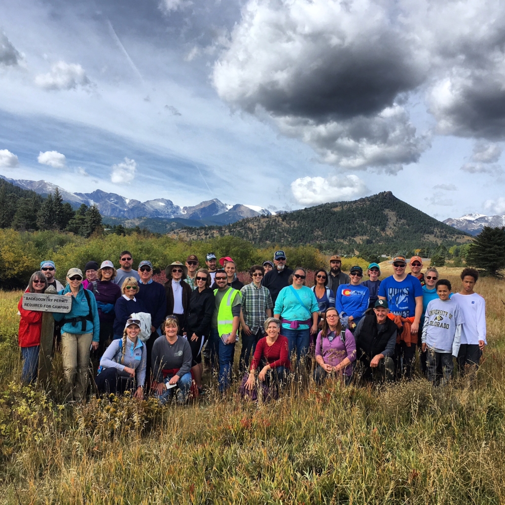 A group of people posing for a photo in a grassy field.