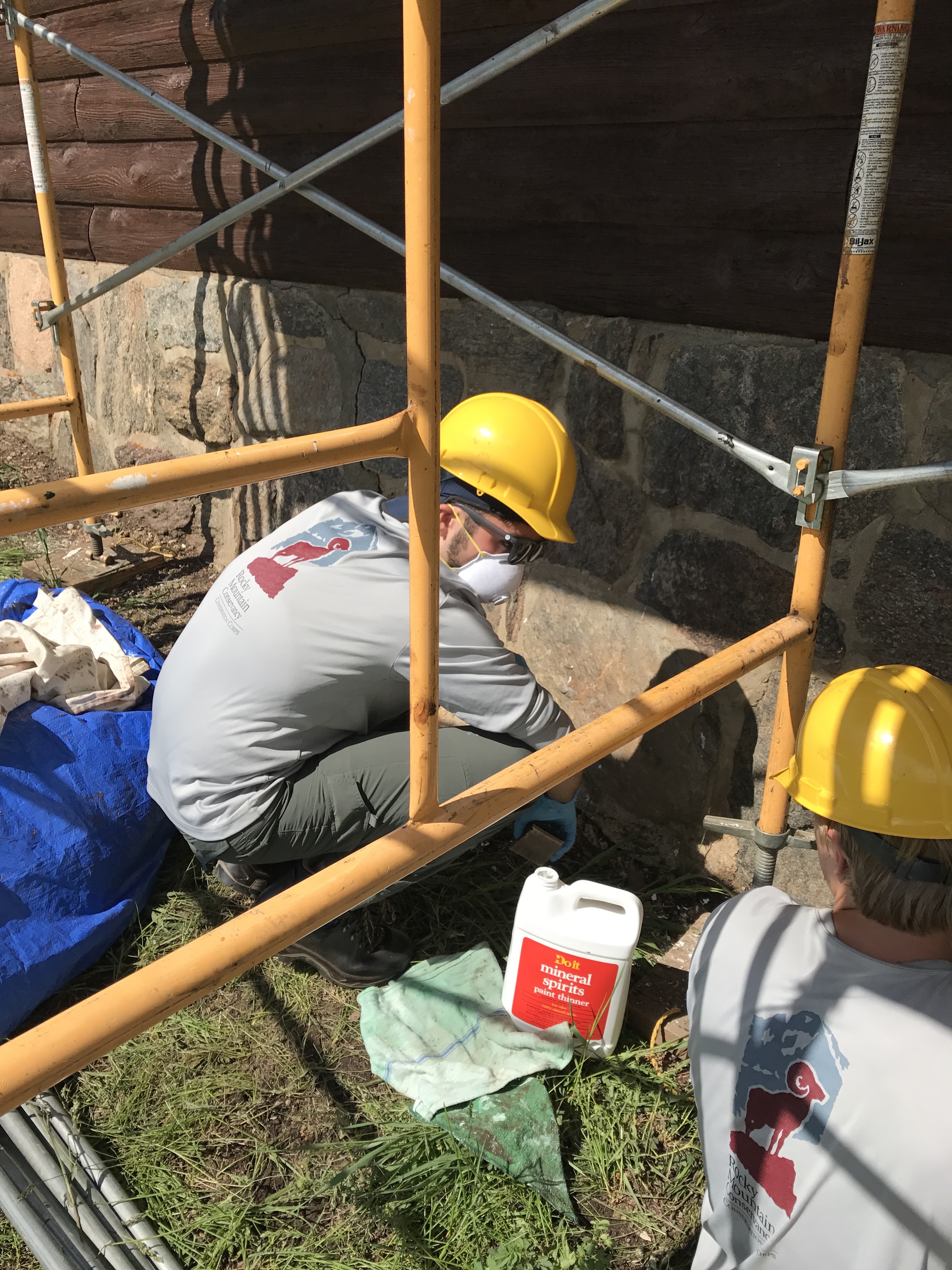 A construction worker applying mortar on stone wall