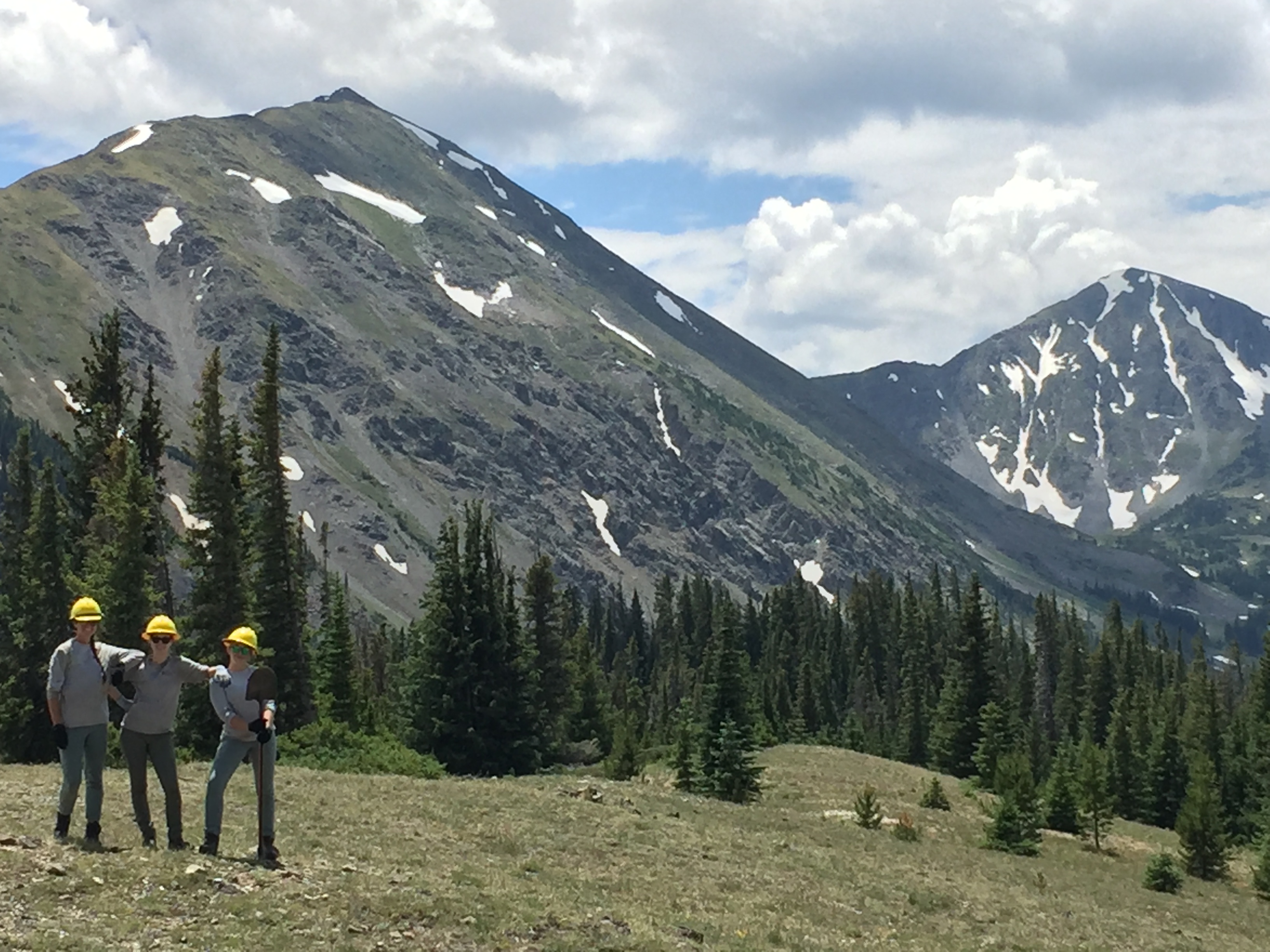 Three people in a mountainous landscape