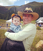 A man in a hat holding a child.