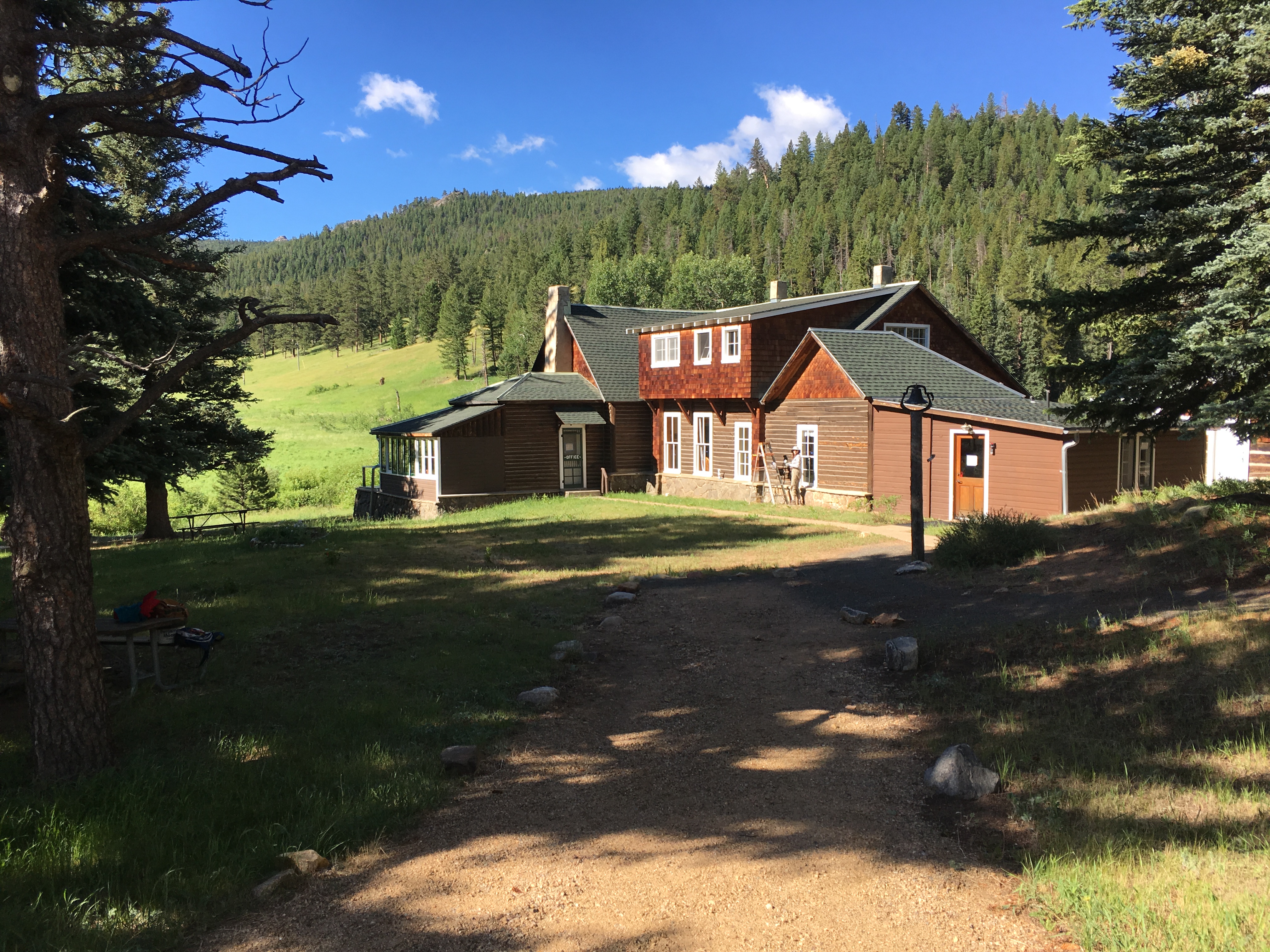 A large wooden cabin situated in a grassy clearing