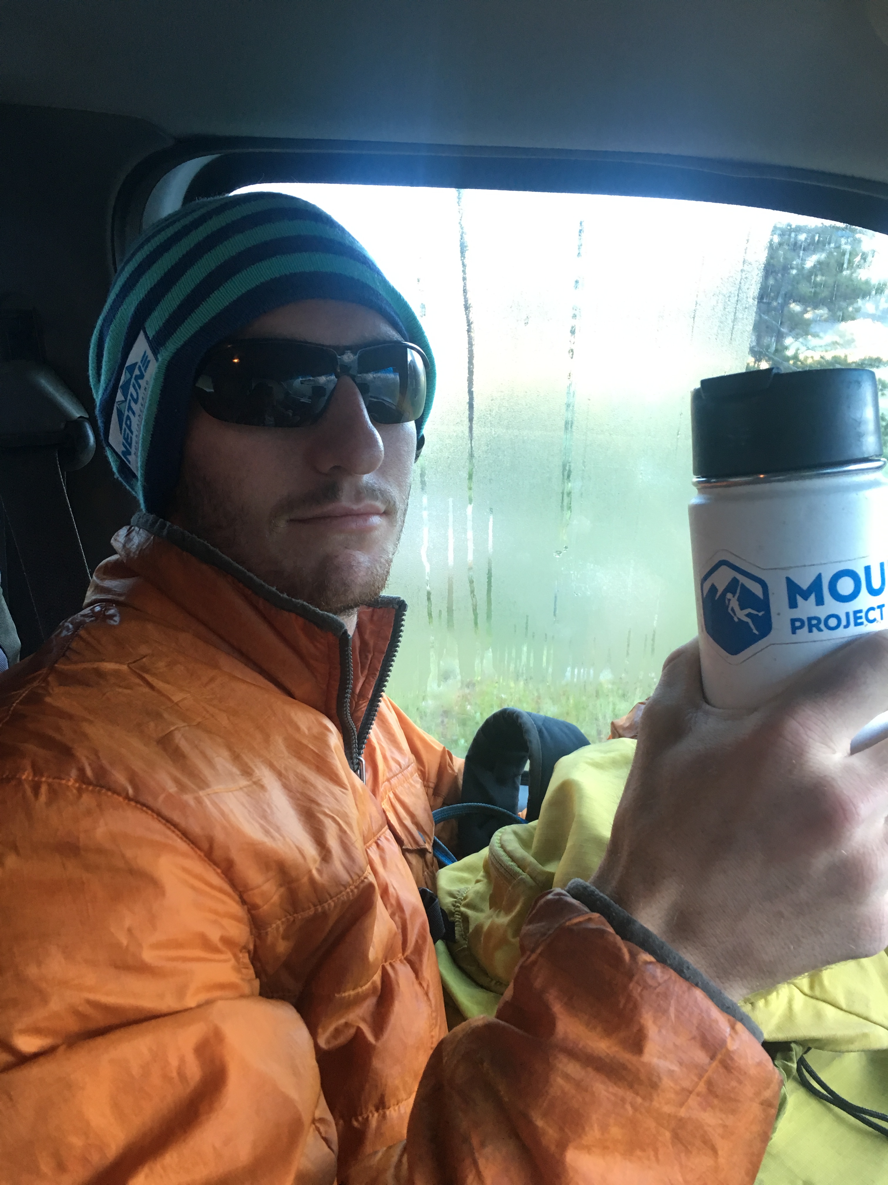 Man holding a thermos inside a vehicle