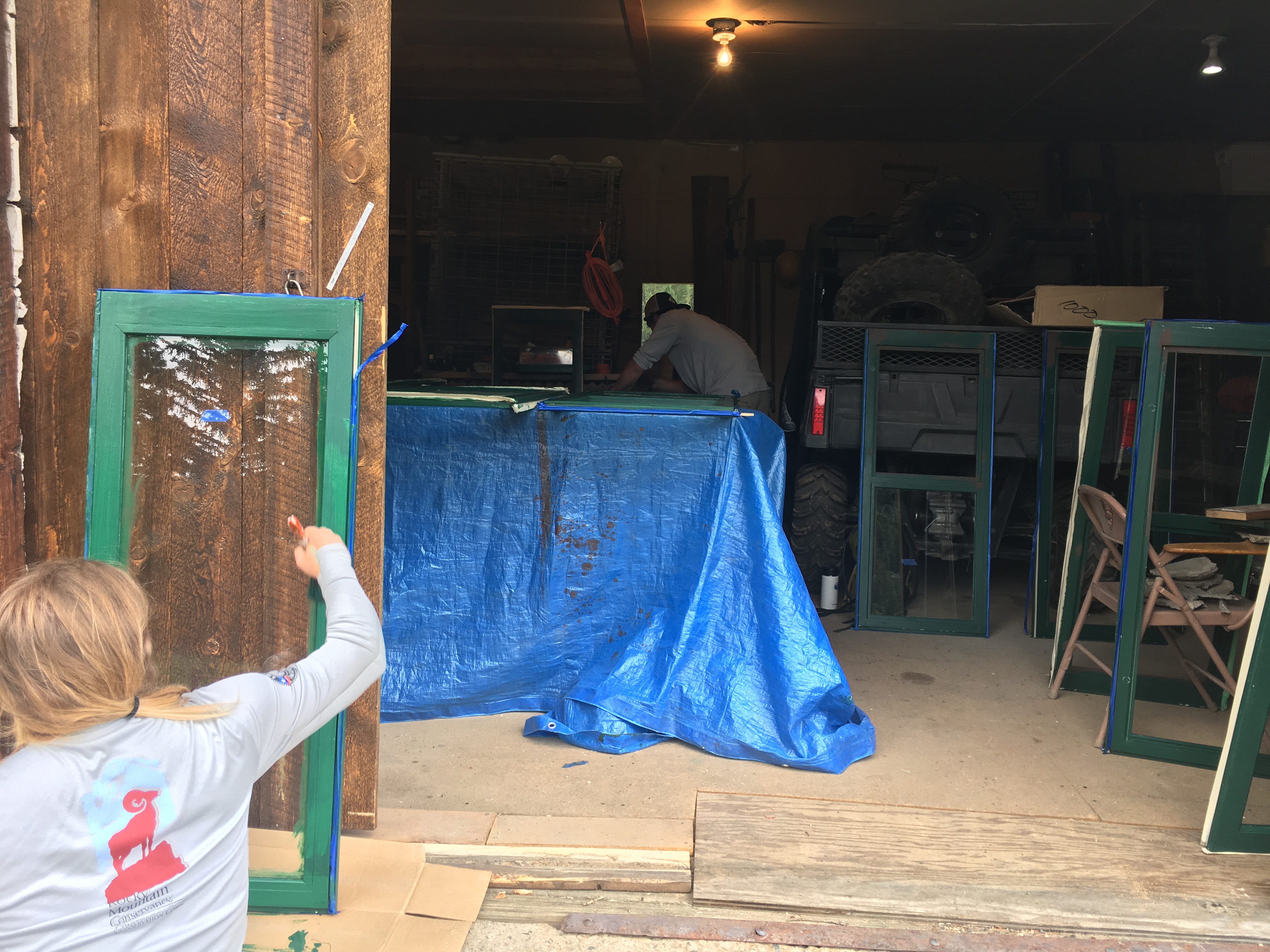 A person paints windows in a workshop