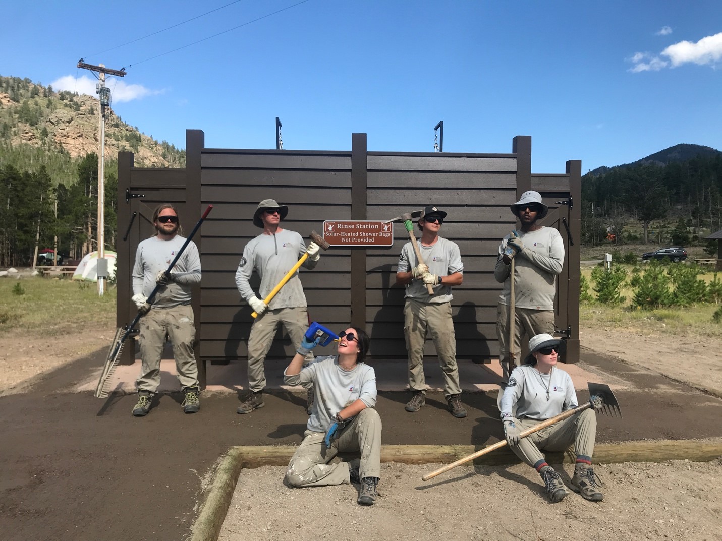 Workers posing for picture while holding tools