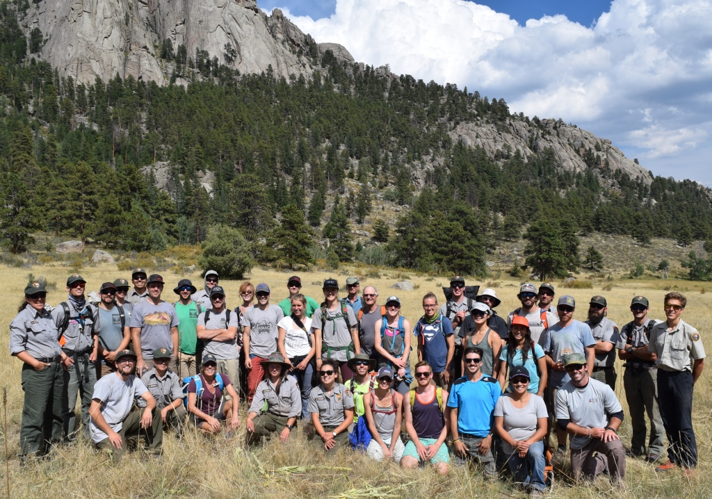 A group of people posing in front of a mountain.