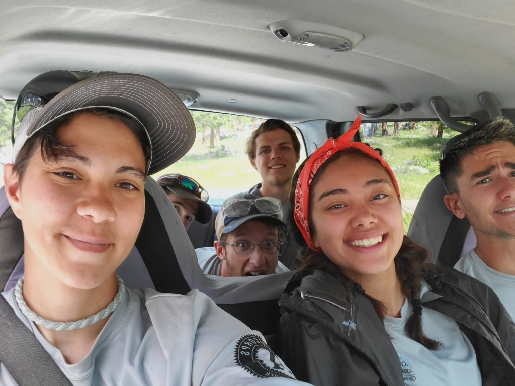 A group of people sitting in the back seat of a car.