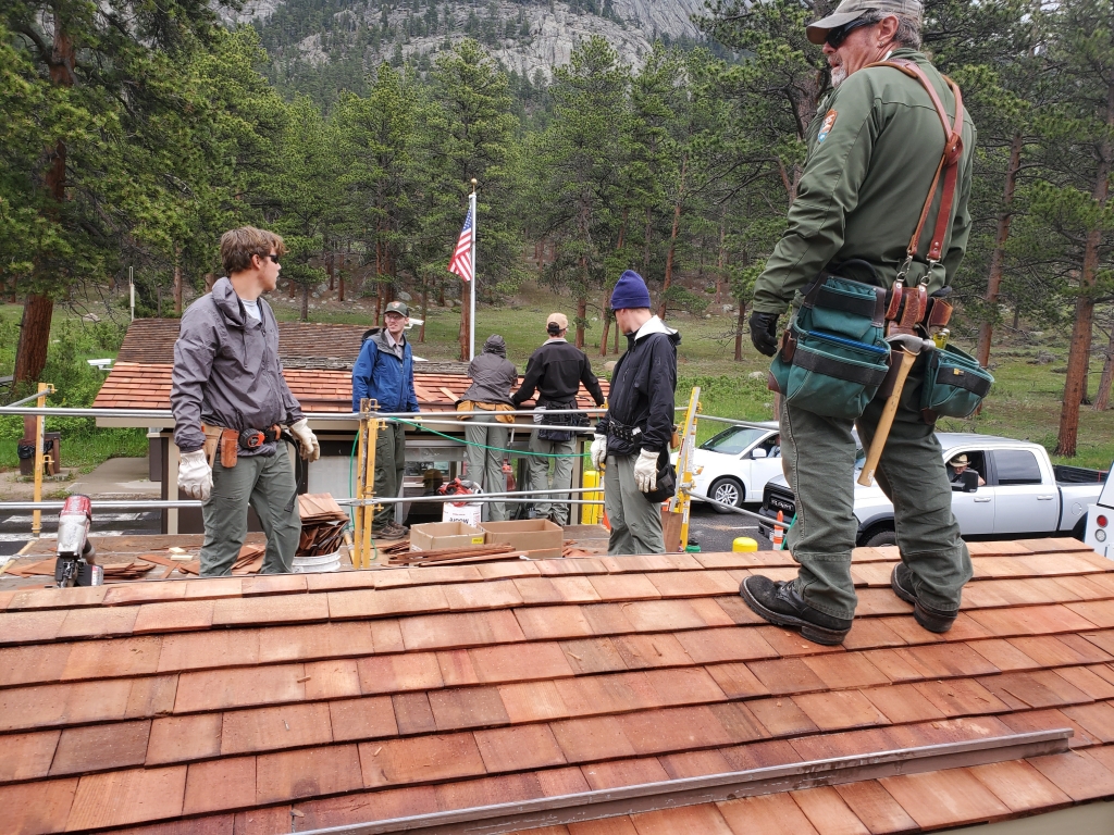 A group of men standing on a roof.