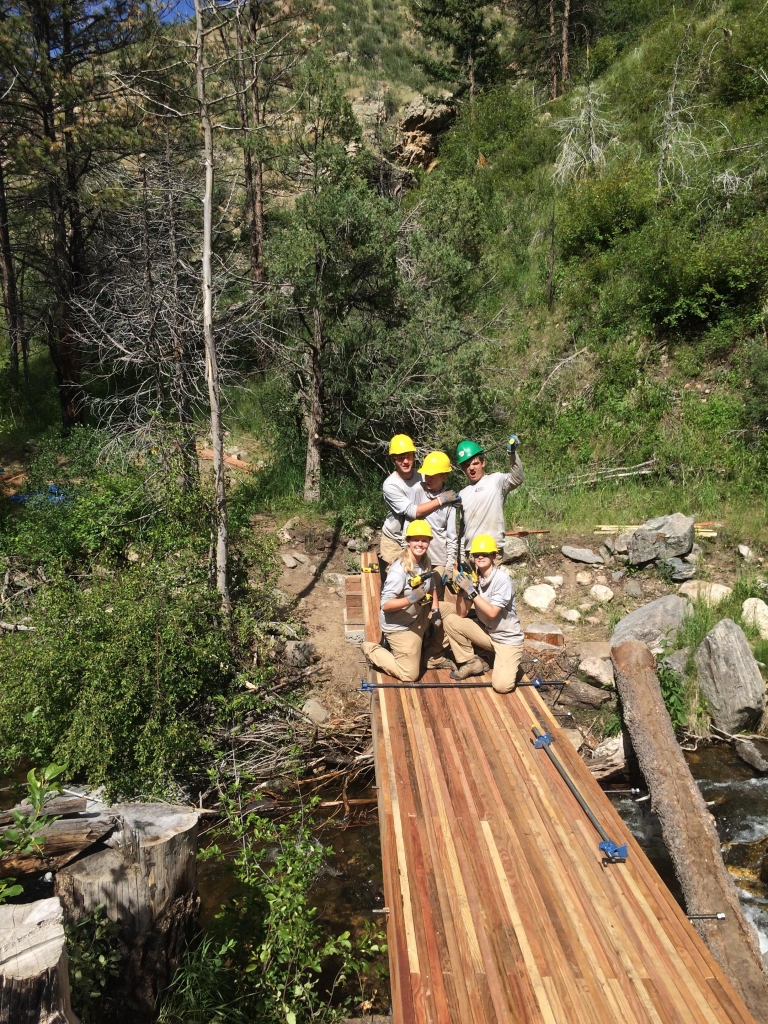 A group of people on a wooden bridge.