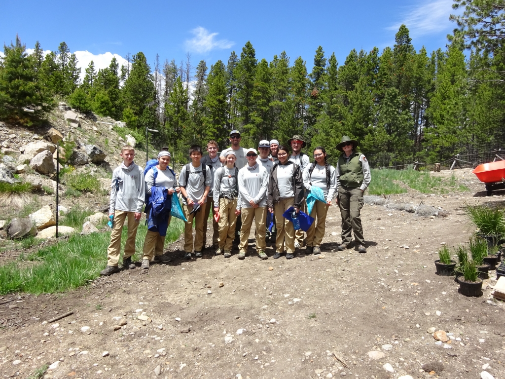 A group of people posing for a picture in the woods.