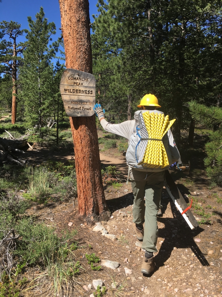 A man carrying a backpack on a trail.