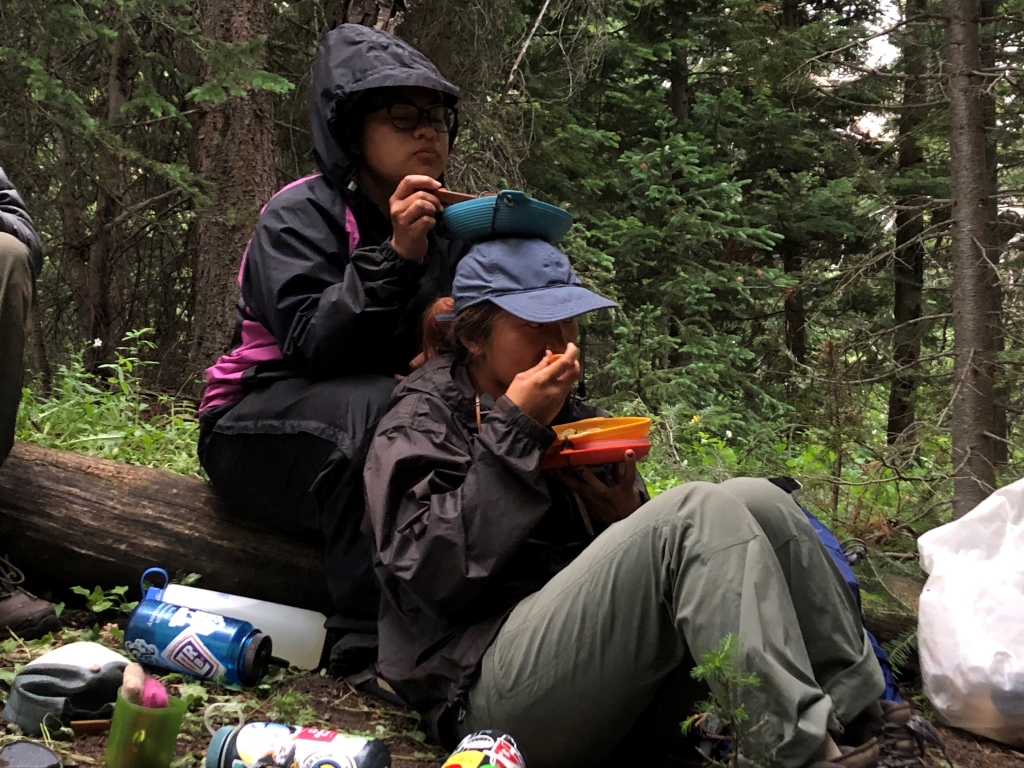 A group of people sitting on a log.