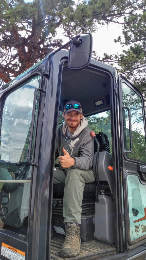 A man sitting in the driver's seat of an excavator.