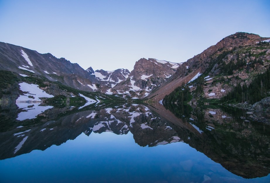 A mountain reflected in a lake at dusk.