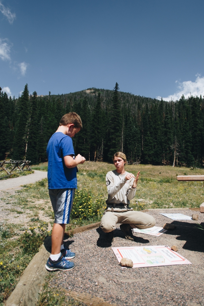 A park ranger explains a map to a young boy.