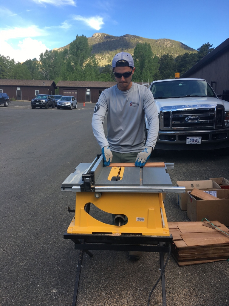 A man using a table saw outdoors.