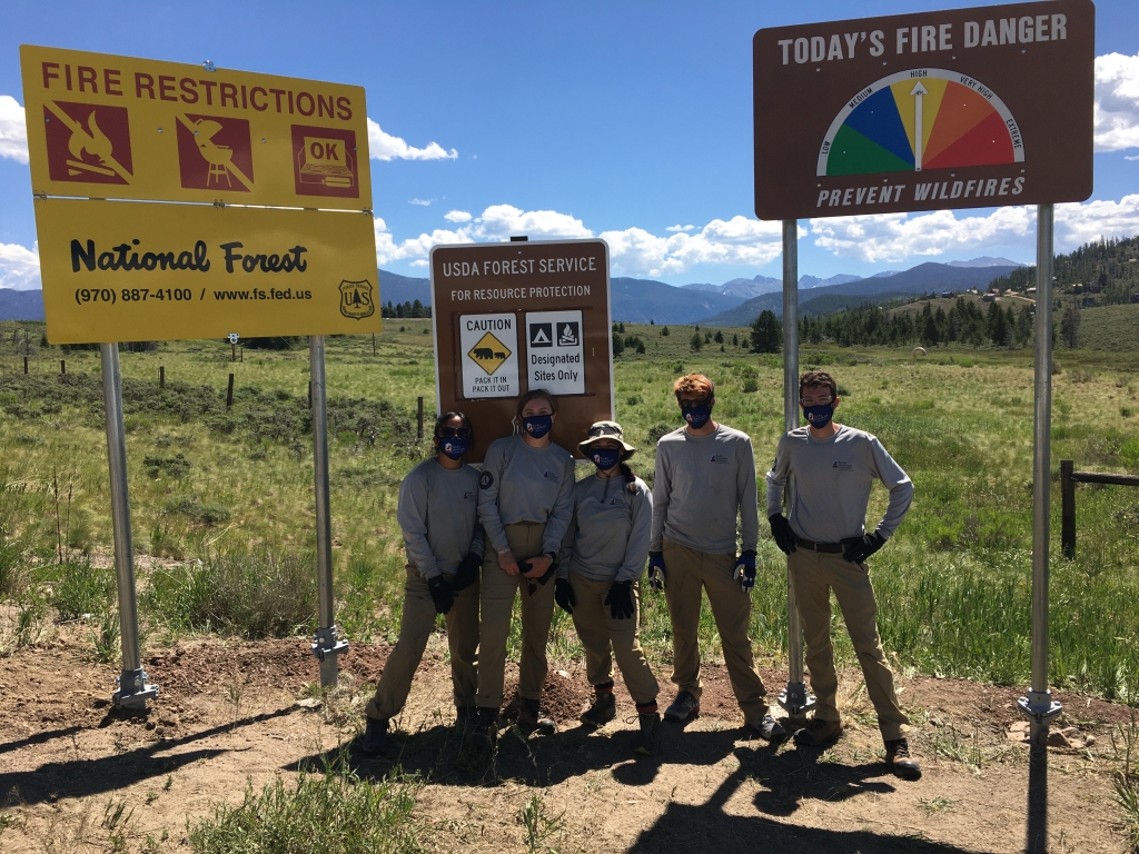 Forest service workers standing in front of informational signs