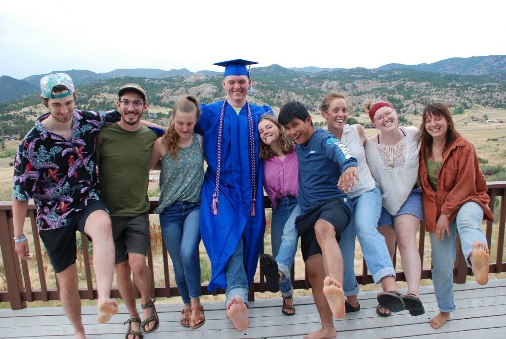 A group of people posing for a photo on a deck.