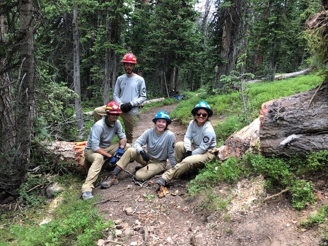 A group of people posing for a photo in the woods.