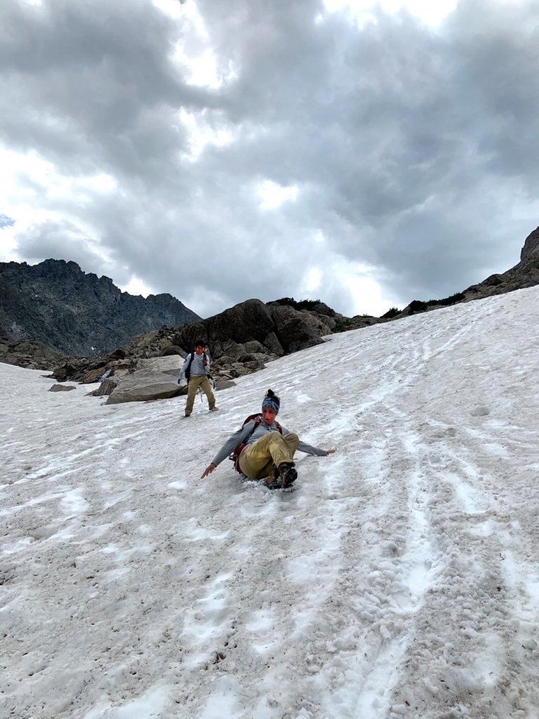 Two hikers descend a snowy mountain slope