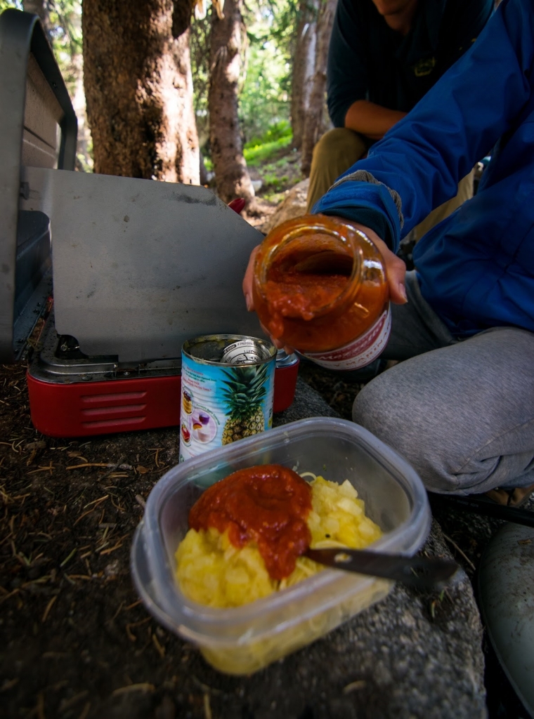 Person pouring sauce from a jar 