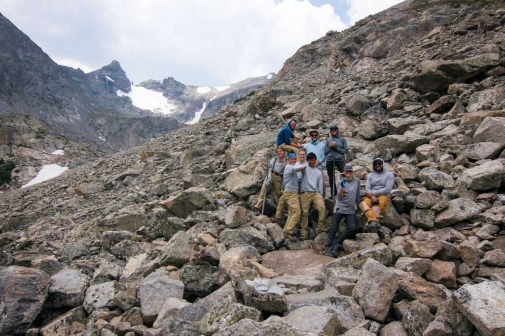 A group of eight hikers posing on a rocky mountain