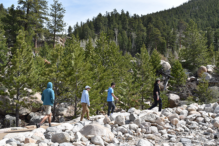 A group of people walking on a rocky path.