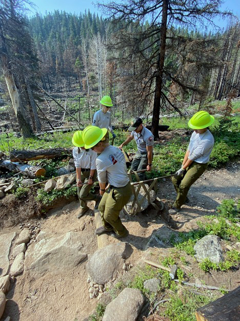 Group of people transporting a rock