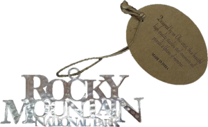 A silver RMNP ornament with the words rocky mountain national park on it.