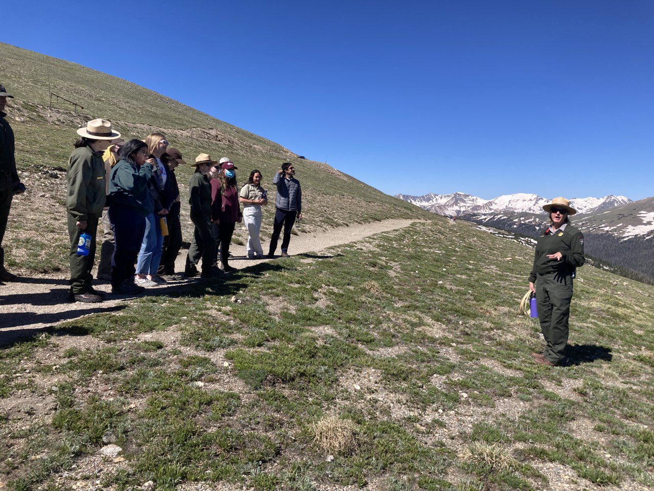 Man discussing towards people on a hill