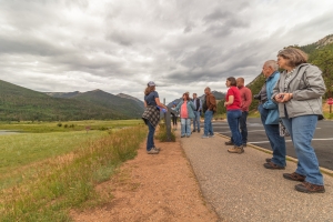 A group of people standing on the side of a road.