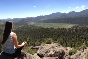 Woman doing yoga on top of hill