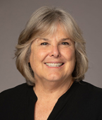 A smiling woman in a black shirt.