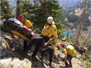 A group of rescuers carrying a stretcher up a mountain.