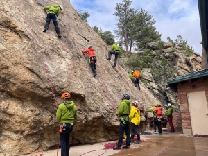 A group of people climbing up a rock wall.