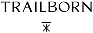 TRAILBORN text in bold capital letters. Below, a minimalist symbol comprising intersecting lines.