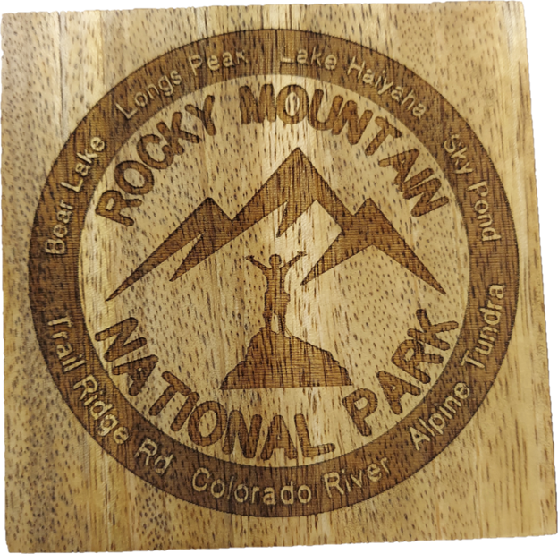 A set of four wooden coasters engraved with "Rocky Mountain National Park" and various park feature names, centered around a mountain and hiker graphic.