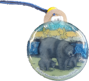 Ornament - RMNP Bear with Cubs: A round souvenir from Rocky Mountain National Park, showcasing an illustration of a bear with two cubs in a forest setting, complete with a blue cord attached at the top.