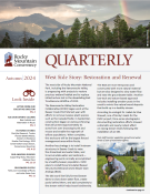 Cover of Rocky Mountain Conservancy Quarterly, Autumn 2024. Features a story on restoration projects with a smiling person in hiking gear holding a plant in a grassy field.